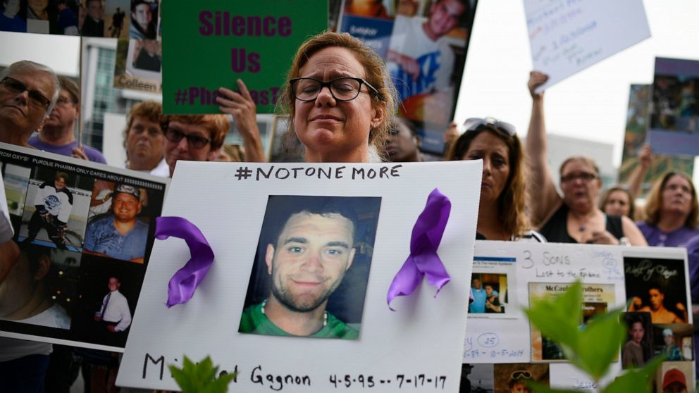 FILE - In this Friday, Aug. 17, 2018 file photo, Christine Gagnon of Southington, Conn. protests with other family and friends who have lost loved ones to OxyContin and opioid overdoses at Purdue Pharma LLP headquarters in Stamford, Conn. Gagnon lost