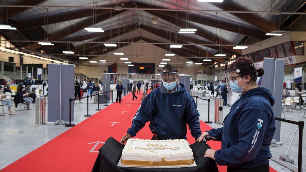 A cake is rolled out to celebrate the nursing students for the class of 2021, so they can gather around the cake during a mini celebration at the Downsview Arena vaccination site, in Toronto, Friday, April 16, 2021. (Tijana Martin/The Canadian Press 