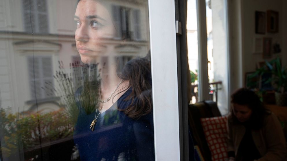 Anais Bulcao, 17, stares through a window of her family apartment in Montmartre, where she lives with her parents, on May 21, 2021. Also living with them again is her elder sister Livia, who was traveling when the pandemic struck and was repatriated 