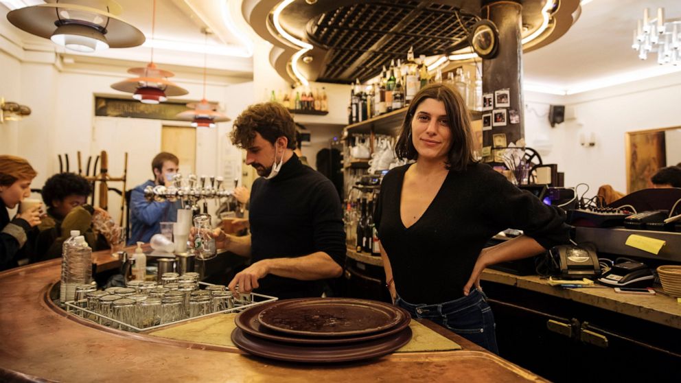 Heloise Brebion, poses inside her bar minutes before the closure, in Paris, Monday, Oct. 5, 2020. French authorities have placed the Paris region on maximum virus alert on Monday, banning festive gatherings and requiring all bars to close but allowin