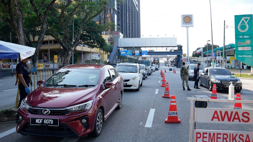 FILE - In this June 1, 2021, file photo, police check passengers in vehicles at a roadblock during the first day of Full Movement Control Order (MCO) in Kuala Lumpur, Malaysia. Malaysia’s Parliament reopened Monday, July 26, 2021 for the first time t