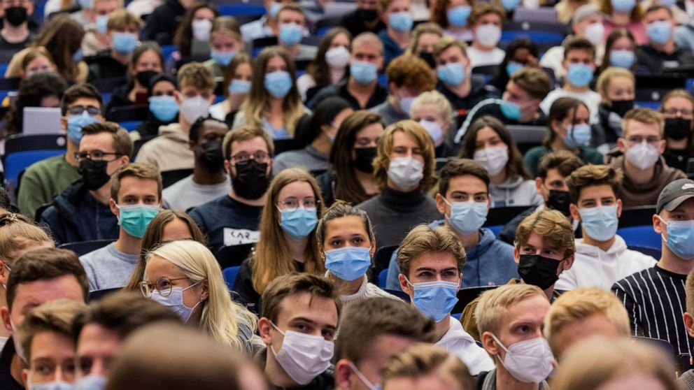 FILE - Students wear mouth-to-nose coverings while sitting close to each other during the lecture 'BWL 1' in lecture hall H1 of the Westfaelische Wilhelms-Universitaet in Muenster, Germany, Wednesday, Oct. 21, 2021. Germany's disease control agency h