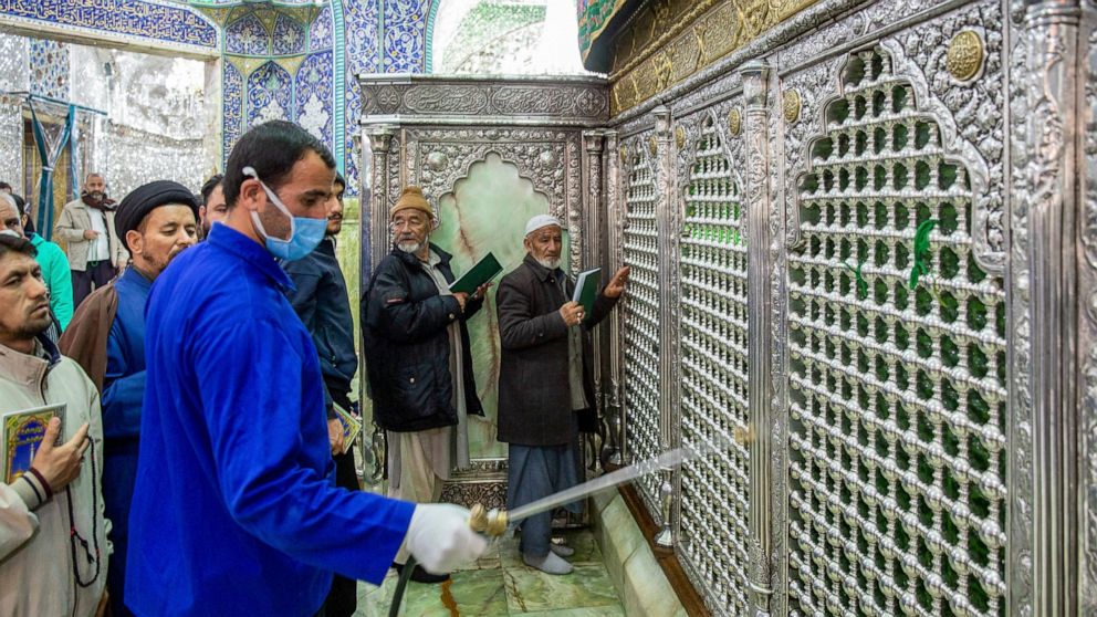 In this Monday, Feb. 24, 2020, photo, a man disinfects the shrine of Saint Masoumeh against coronavirus in the city of Qom 78 miles (125 kilometers) south of the capital Tehran, Iran. Iran's government said Monday that 12 people had died nationwide f