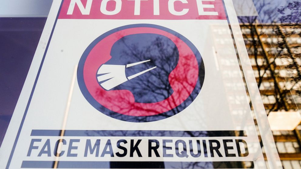 FILE - A sign requiring masks as a precaution against the spread of the coronavirus on a store front in Philadelphia, is seen Feb. 16, 2022. Philadelphia is reinstating its indoor mask mandate after reporting a sharp increase in coronavirus infection