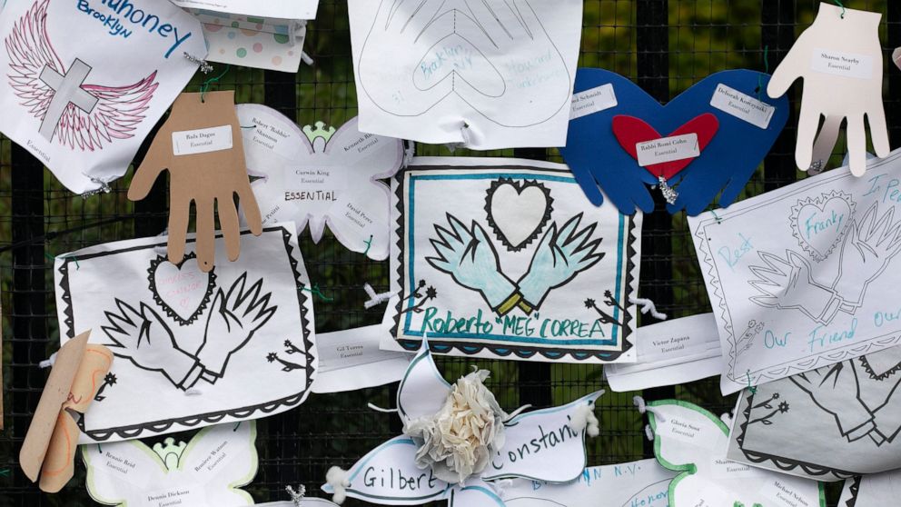FILE - In this May 28, 2020, file photo, Tributes to lost love ones adorn a fence outside Brooklyn's Green-Wood Cemetery where many victims of COVID-19 are buried in New York. The U.S. death toll from COVID-19 has topped 600,000, even as the vaccinat