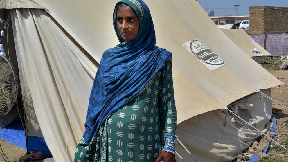Shakeela Bibi who is pregnant stands beside her tent at a relief camp for flood victims, in Fazilpur near Multan, Pakistan, Sept. 23, 2022. Pregnant women are struggling to get care after Pakistan’s unprecedented flooding, which inundated a third of 