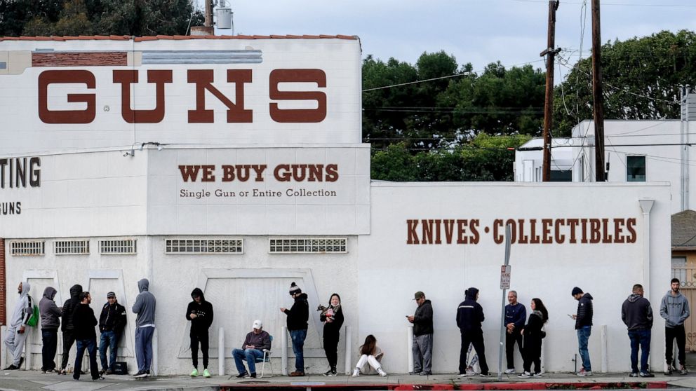 FILE - In this March 15, 2020 file photo people wait in a line to enter a gun store in Culver City, Calif. The 9th U.S. Circuit Court of Appeals on Thursday, Jan. 20, 2022, overturned two California counties orders shutting down gun and ammunition st
