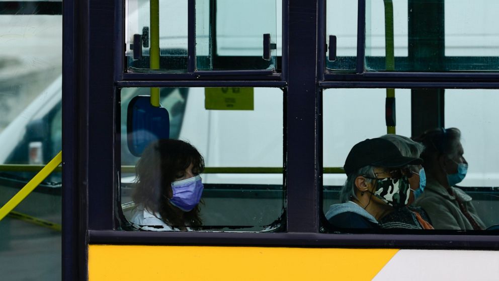 Commuters wearing face masks to curb the spread of COVID-19 are seen in a bus, in Athens, Greece, Tuesday, Nov. 9, 2021. Greece reported a new record high for daily COVID-19 infections on Monday as vaccination appointments shot up after new restricti