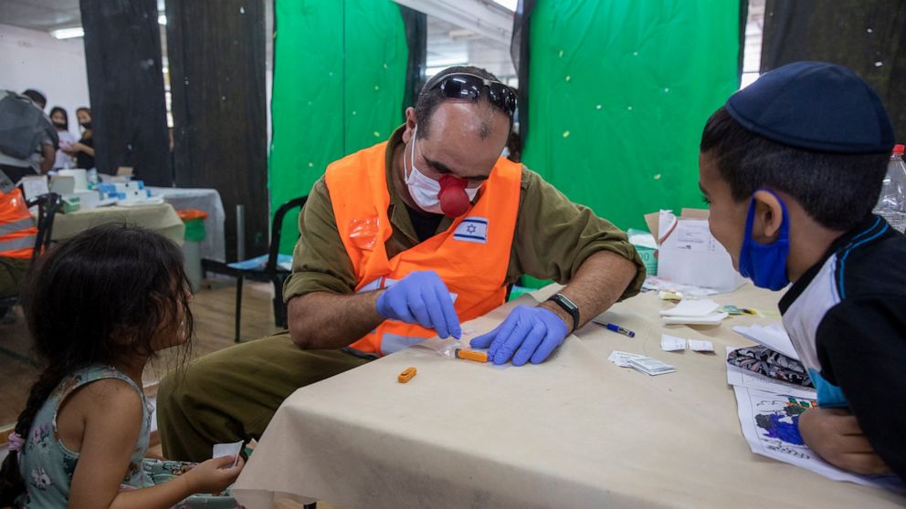 An Israeli soldier conducts a COVID-19 antibody test on a child in Hadera, Israel, Monday, Aug. 23, 2021. Ahead of the opening of the school year on Sept. 1, the Israeli army's Home Front Command is conducting serology tests on children age 3-12 who 