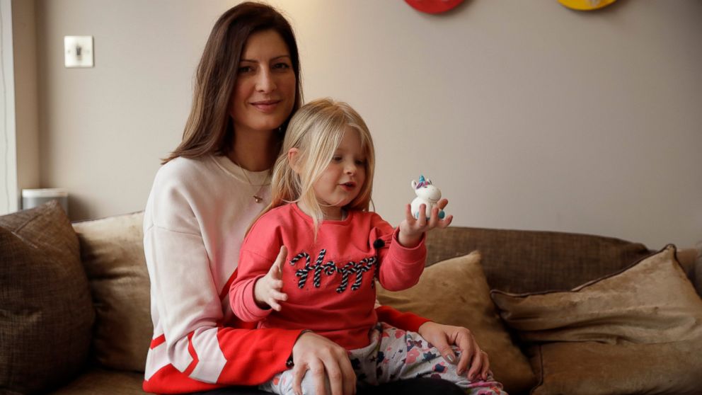 In this Wednesday, Jan. 23, 2019 photo, Victoria Mickleburgh and her daughter Grace pose for photographs at their home in Cobham on the outskirts of south west London. Things are already tough for Mickleburgh, whose 3-year-old daughter Grace, has Typ