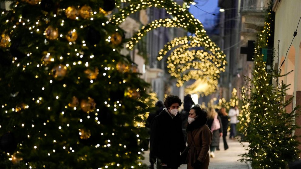 Pedestrian stroll along Via Montenapoleone fashion district decorated with seasonal lights, in Milan, Italy, Thursday, Dec. 23, 2021. The Italian government is weighing possible outdoor mask mandates, increased testing and other measures to combat th