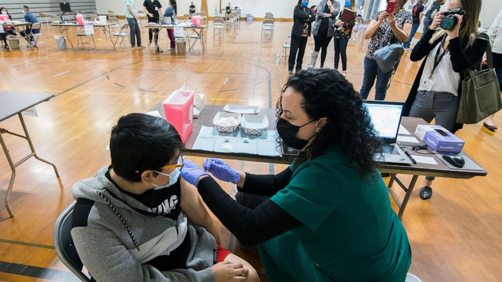 Nurse Jessica Lipscomb gives Miguel Castro, 13, of Brentwood, the Pfizer COVID-19 vaccine in the Antioch Middle School gym in Antioch, Calif., May 19, 2021. In partnership with Kaiser Permanente and the Contra Costa Office of Education, the Contra Co