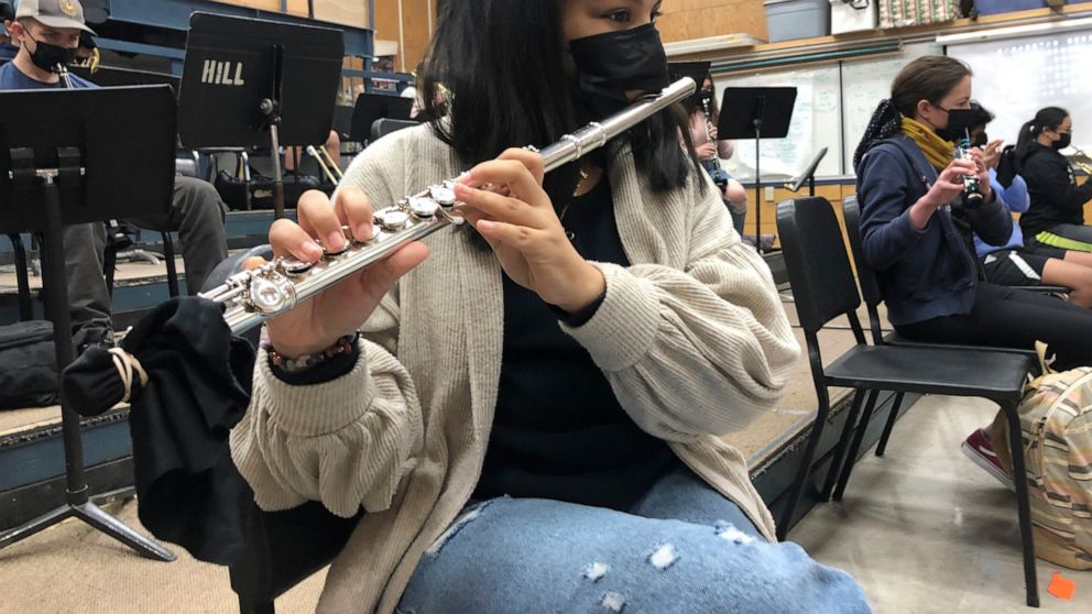 FILE - In this March 2, 2021 file photo, a student plays the flute while wearing a protective face mask during a music class at the Sinaloa Middle School in Novato, Calif. With COVID-19 cases soaring nationwide, school districts across the U.S. are y