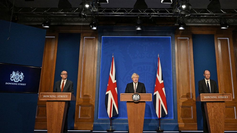Britain's Prime Minister Boris Johnson, center, speaks during a media briefing on coronavirus in Downing Street, London, Monday, July 5, 2021. Johnson says people in England will no longer be required by law to wear face masks in indoor public spaces