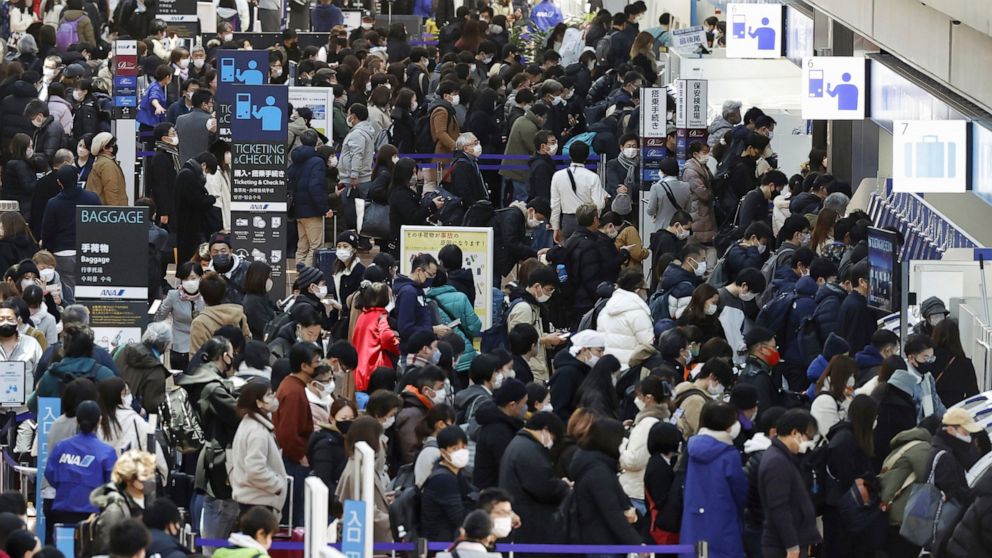 Travelers crowd at a departure lobby of Haneda airport in Tokyo Thursday, Dec. 29, 2022. Japan on Thursday reported a record 420 single-day coronavirus deaths, one day after reaching an earlier record of 425 deaths, according to the Health Ministry. 
