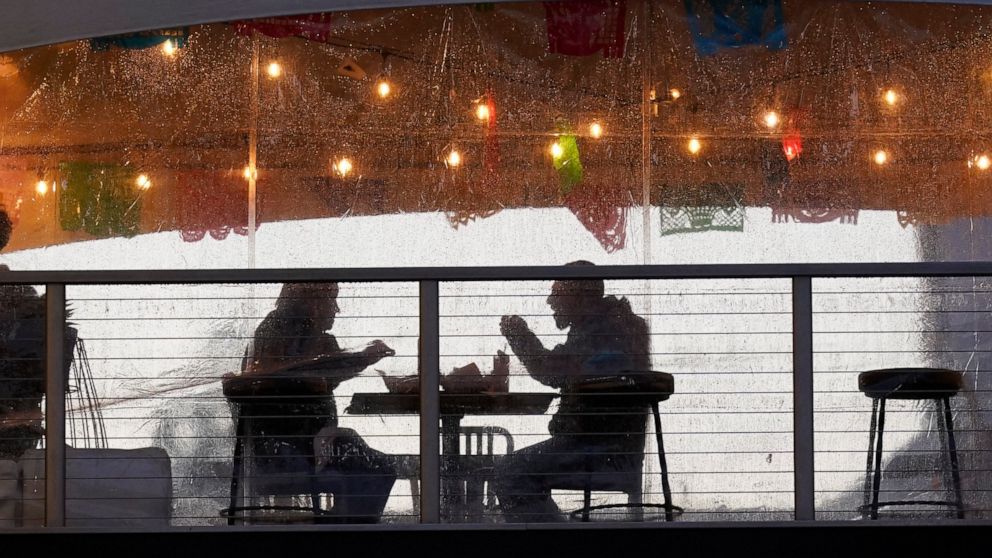FILE - In this Jan. 22, 2021, file photo, diners have dinner at an outdoor dining area at the Polanco Cantina in Sacramento, Calif. California has lifted regional stay-at-home orders statewide in response to improving coronavirus conditions. Public h