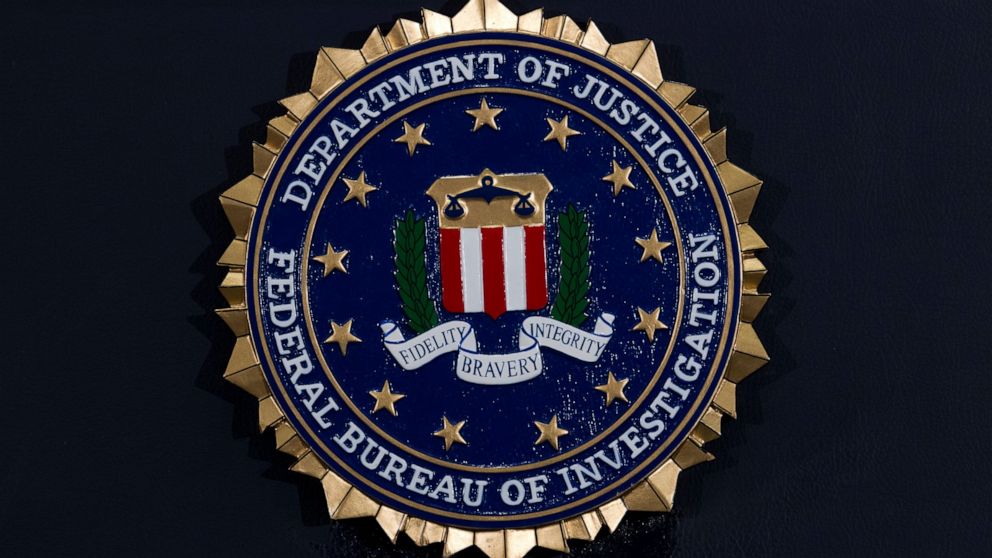 FILE - This Thursday, June 14, 2018, file photo, shows the FBI seal at a news conference at FBI headquarters in Washington. In an alert Wednesday, Oct. 28, 2020, the FBI and other federal agencies warned that cybercriminals are unleashing a wave of d