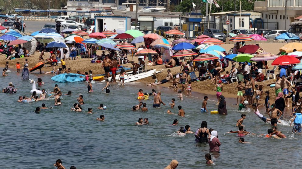 Beachgoers enjoy the el Djamila beach after its reopening in Algiers, Saturday, Aug.15, 2020. Algeria started to reopen mosques, cafes, beaches and parks Saturday after five months of virus confinement measures. Curfews are still in place in more tha
