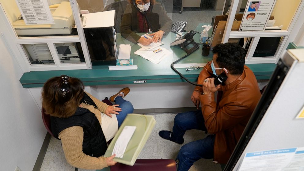 Mohammad Attaie and his wife Deena, newly arrived from Afghanistan, get assistance from medical translator Jahannaz Afshar making a doctor's appointment at the Valley Health Center TB/Refugee Program in San Jose, Calif., on Dec. 9, 2021. The staff of