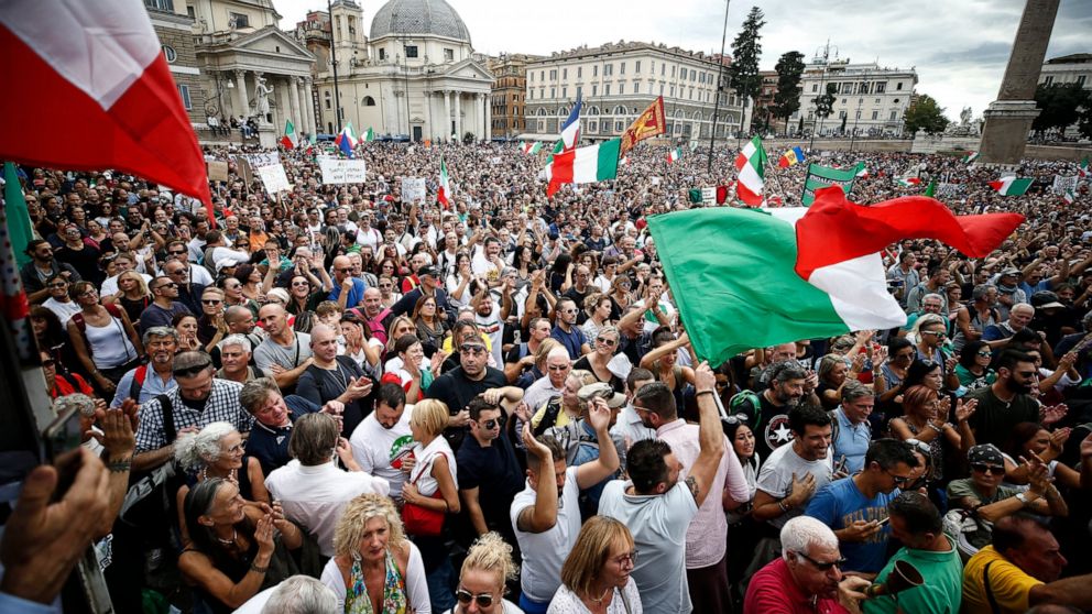 People gather in Piazza del Popolo square during a protest, in Rome, Saturday, Oct. 9, 2021. Thousands of demonstrators protested Saturday in Rome against the COVID-19 health pass that Italian workers, both the public and private sectors, must displa