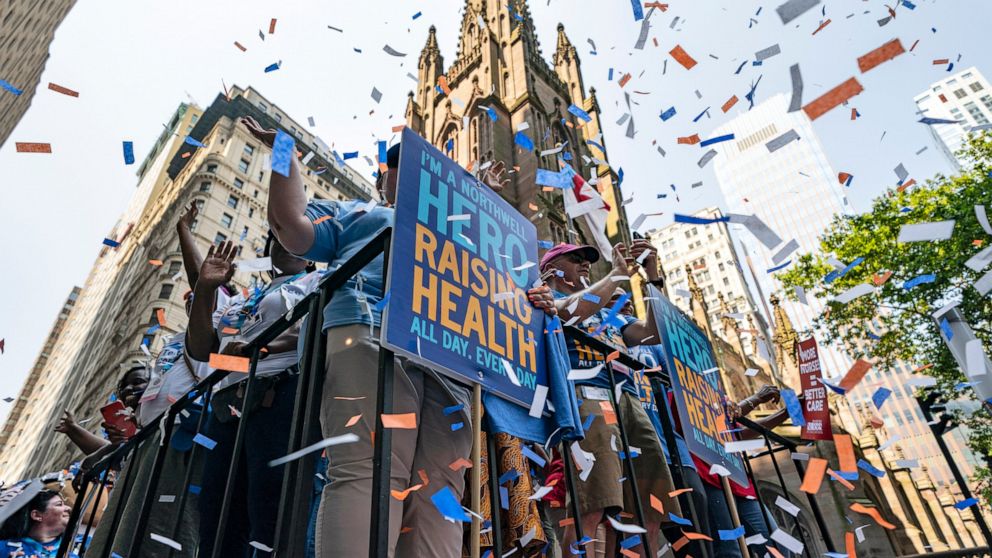 Participants on floats move up Broadway through the Financial District as confetti falls during a parade honoring essential workers for their efforts in getting New York City through the COVID-19 pandemic, Wednesday, July 7, 2021, in New York. The pa
