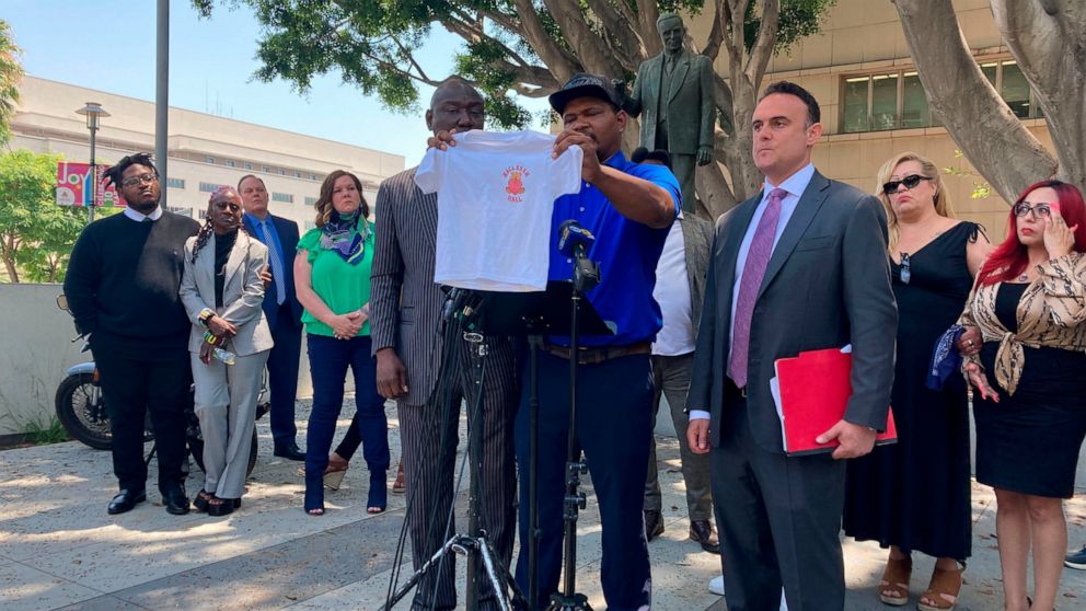Jonathan Wright, 39, holds up the T-shirt he was given when he first went to MacLaren Children's Center in El Monte as an 8-year-old during a news conference in Los Angeles, Thursday, June 9, 2022. He said he was sexually abused by a physician there.