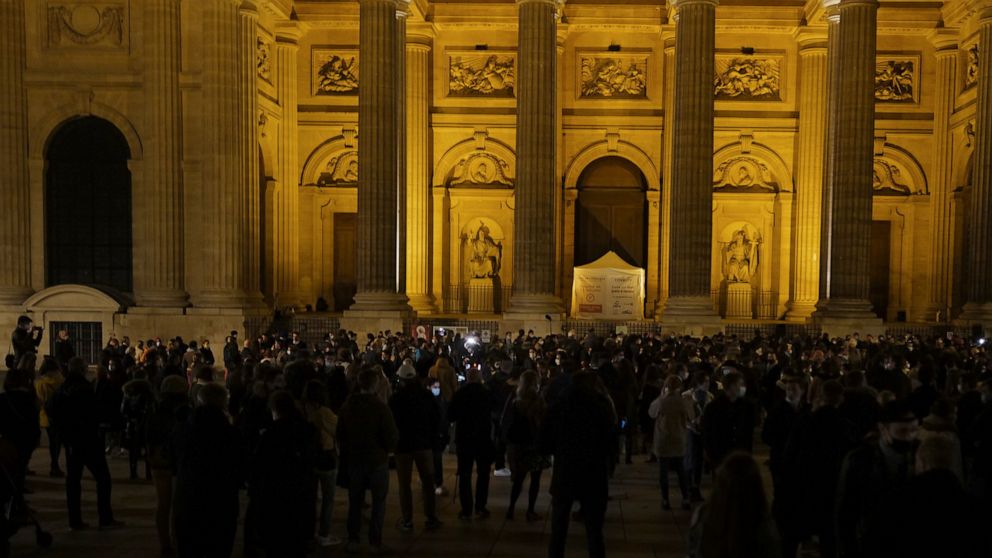 French believers stand and chant religious songs in front of Saint Sulpice Catholic church, in Paris, Friday, Nov. 13, 2020. Dozens of believers gather to protest against the government measures to close churches as part of the monthlong partial lock