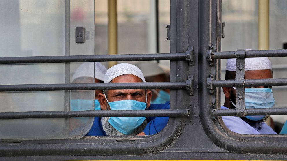 FILE - In this March 31, 2020, file photo, Muslim pilgrims wait in bus that will take them to a quarantine facility, after a government raid discovered the largest viral cluster in India at the Nizamuddin area of New Delhi, India. Muslims in India ar