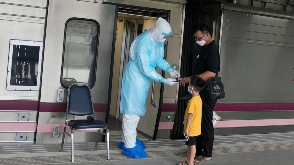 A health worker checks oxygen level for a COVID-19 patient upon his arrival at Rangsit train station in Pathum Thani province, Thailand, Tuesday, July 27, 2021. Thai authorities began transporting some people who have tested positive with the coronav