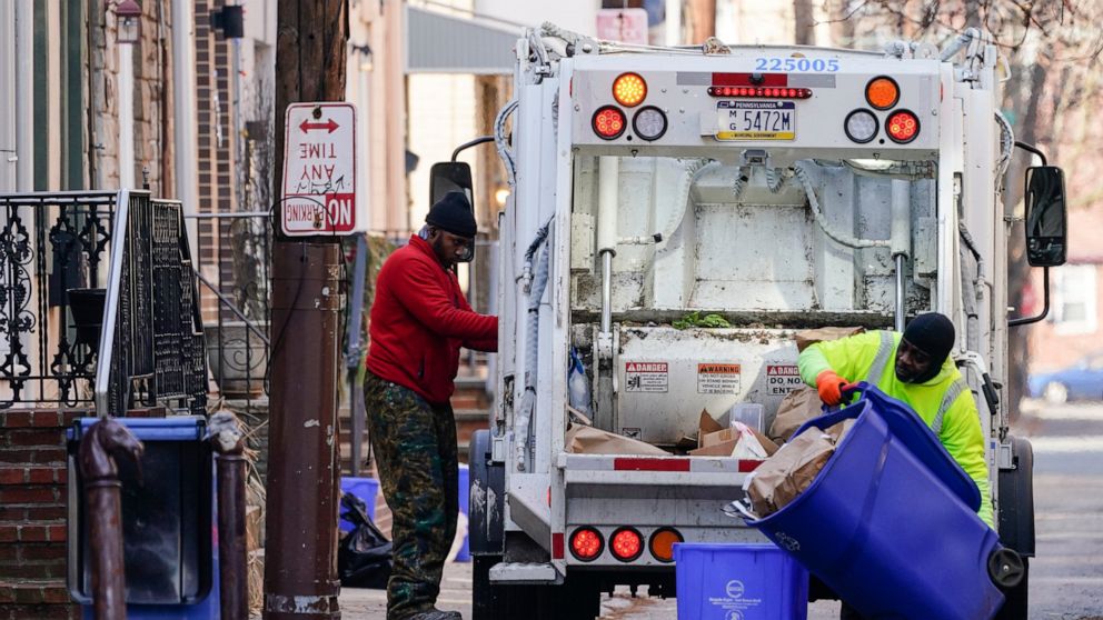 Municipal sanitation workers collect trash in Philadelphia, Thursday, Jan. 13, 2022. The omicron variant is sickening so many sanitation workers around the U.S. that waste collection in Philadelphia and other cities has been delayed or suspended. (AP