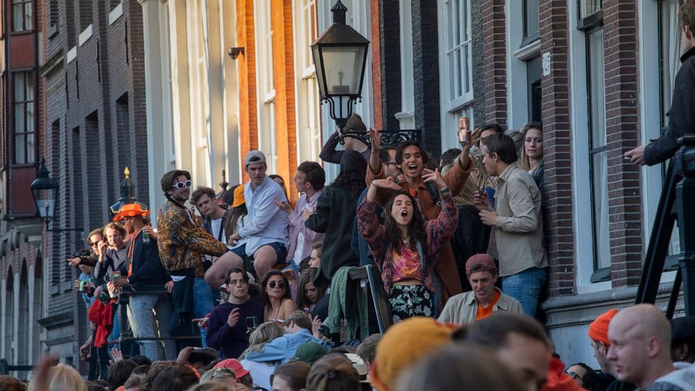 FILE - In this Tuesday, April 27, 2021 file photo, people gather despite authorities urging people to stick to coronavirus social distancing regulations, as they celebrate King's Day in the center of Amsterdam, Netherlands. Dutch zoos and theme parks