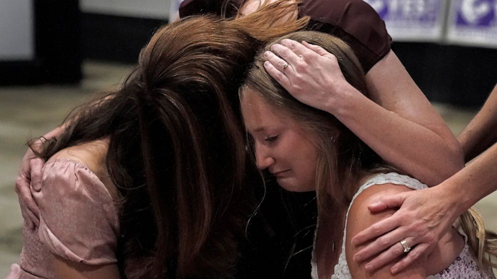Hannah Joerger, left, Amanda Grosserode, center, and Mara Loughman hug during a Value Them Both watch party after a question involving a constitutional amendment removing abortion protections from the Kansas constitution failed Tuesday, Aug. 2, 2022,