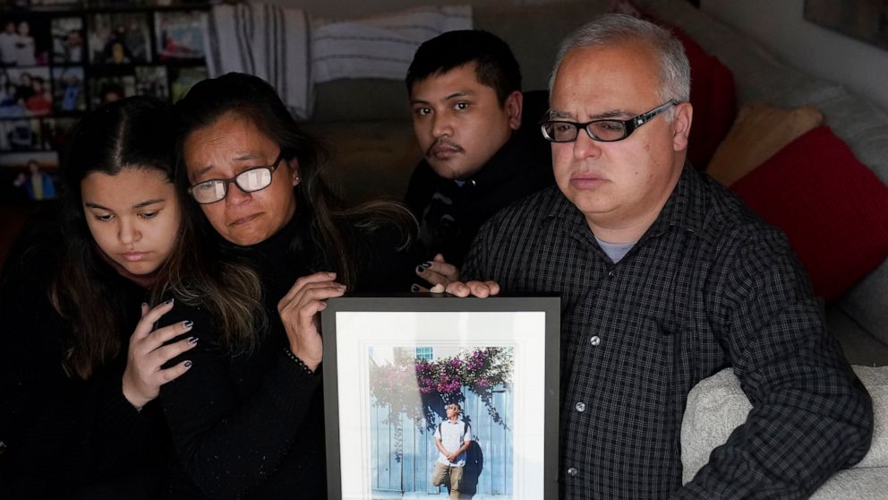 Cassandra Quinto-Collins, second from left, holds a photo of her son, Angelo Quinto, while sitting with daughter Bella Collins, left, son Andrei Quinto, center, and husband Robert Collins during an interview in Antioch, Calif., Tuesday, March 16, 202