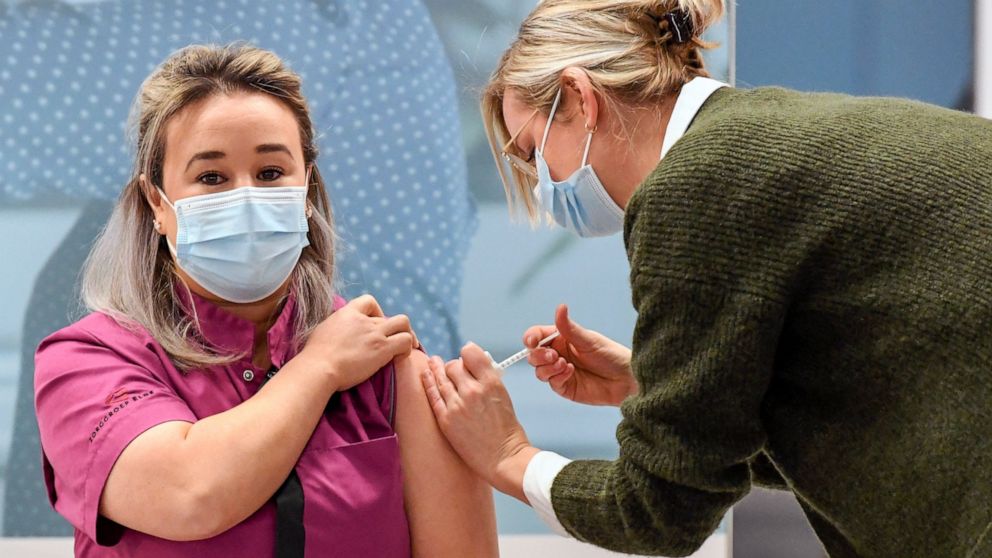 Healthcare worker Sanna Elkadiri, left, was the first Dutch recipient of a shot of the Pfizer-BioNTech coronavirus vaccine at a mass vaccination center in Veghel, Netherlands, Wednesday Jan. 6, 2021. Nearly two weeks after most other European Union n