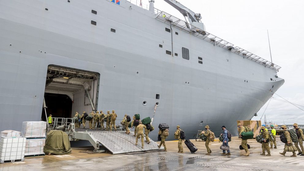 In this photo provided by the Australian Defense Force, soldiers load onto HMAS Adelaide at the Port of Brisbane before departing for Tonga Thursday, Jan. 20, 2022, after a volcano eruption. Nearly two dozen sailors aboard the Adelaide have tested po