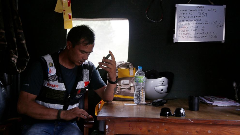 Arun Saiju of the RNA-16 volunteer group speaks on a phone inside his makeshift shelter during lockdown at a hospital in Bhaktapur, Nepal, Tuesday, May 26, 2020. RNA-16 stands for “Rescue and Awareness” and the 16 kinds of disasters they have prepare