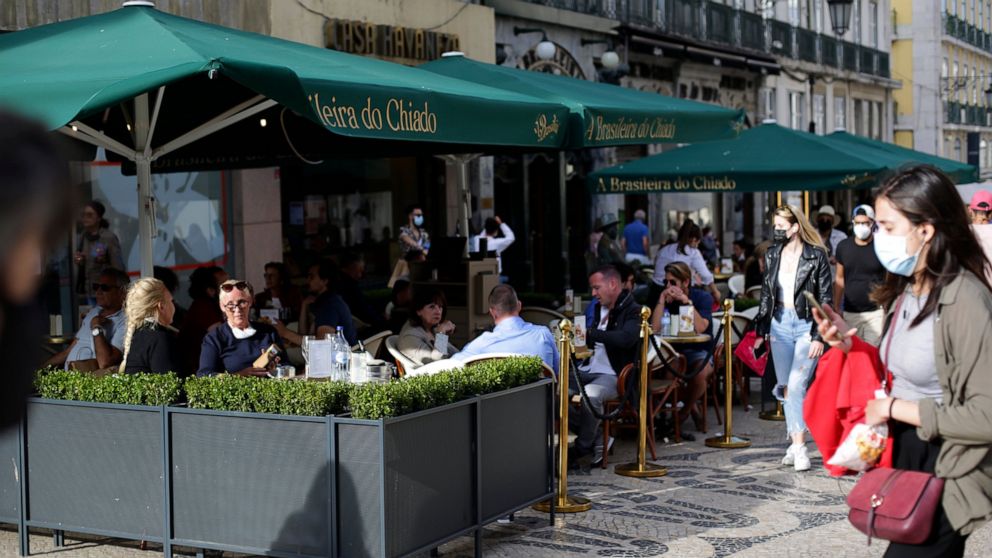 People sit a cafe terrace in downtown Lisbon, Friday, June 4, 2021. Britain said Thursday that it is removing Portugal from its list of COVID-safe travel destinations, meaning thousands of U.K. residents currently on vacation there face the prospect 