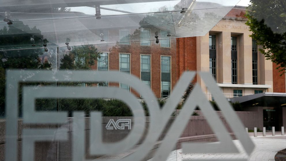 This Aug. 2, 2018, file photo shows the U.S. Food and Drug Administration building behind FDA logos at a bus stop on the agency's campus in Silver Spring, Md. The U.S. government isn’t doing routine food inspections because of the partial federal shu