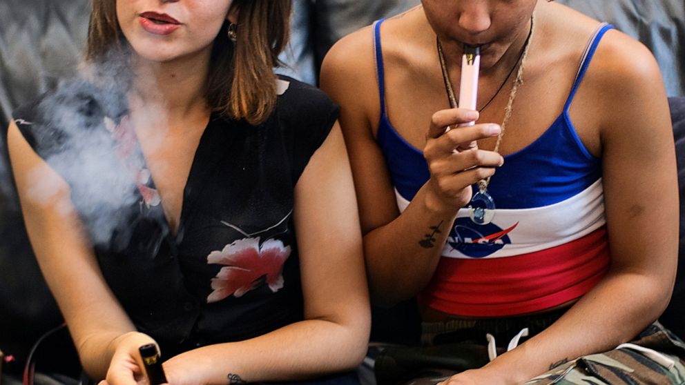 FILE - In this Saturday, June 8, 2019 file photo, two women smoke cannabis vape pens at a party in Los Angeles. On Friday, Sept. 27, 2019, the Centers for Disease Control and Prevention said more than three-quarters of the 805 confirmed and probable 