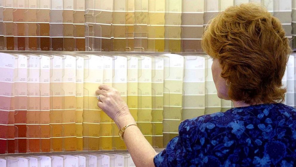 FILE - In this June 28, 2004, file photo, a customer looks over color chips at a Sherwin-Williams store in Columbus, Ohio. The nation's major suppliers of lead paint have agreed to pay California's largest cities and counties $305 million to settle a