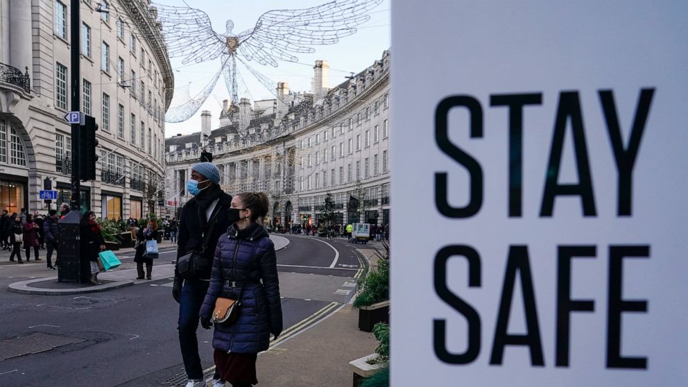 FILE - People wear face masks as they walk, in Regent Street, in London, Sunday, Nov. 28, 2021. The number of new coronavirus cases across Britain has surged by more than 30% in the last week, with cases largely driven by the super infectious omicron