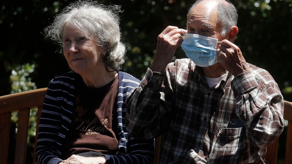 Larry Yarbroff, right, adjusts his mask as he sits with his wife, Mary, while visiting her at Chaparral House in Berkeley, Calif., Friday, July 10, 2020. For months, families have pined to see their loved ones in California's skilled nursing faciliti