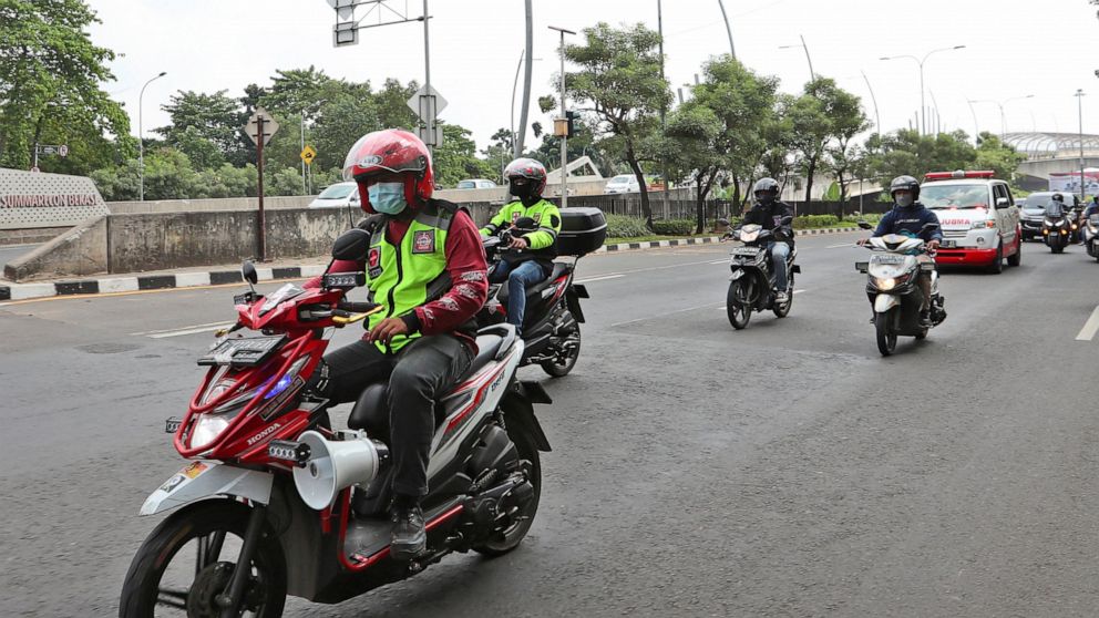 Motorcycle volunteers escort an ambulance carrying the body of a COVID-19 victim on its way to a cemetery for burial, in Bekasi on the outskirts of Jakarta, Indonesia on July 11, 2021. The two-wheeled volunteers provide a key service in the sprawling