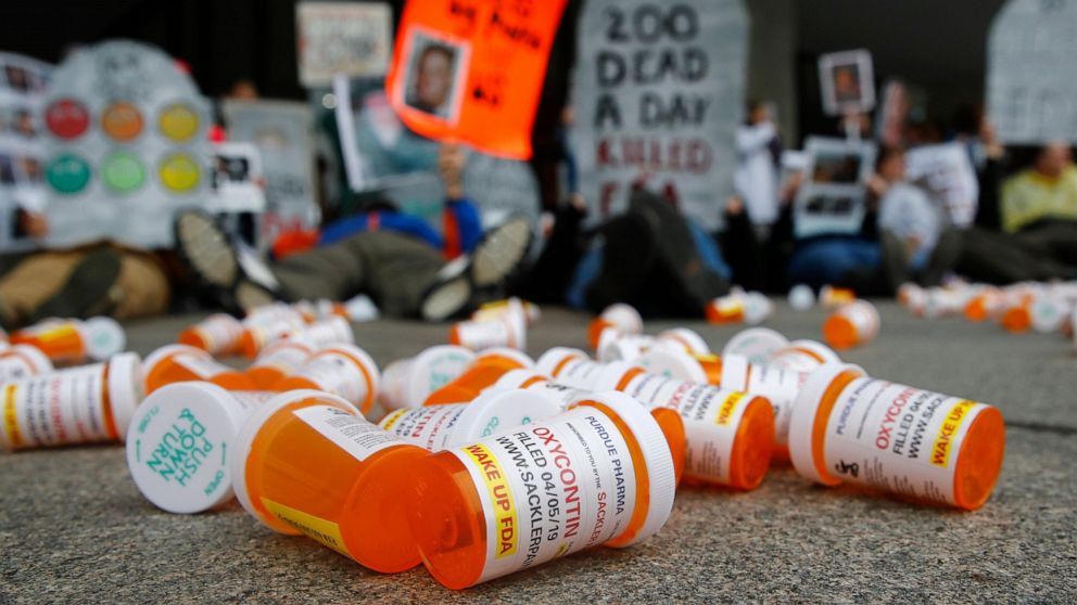 FILE - In this April 5, 2019, file photo, containers depicting OxyContin prescription pill bottles lie on the ground in front of the Department of Health and Human Services' headquarters in Washington as protesters demonstrate against the FDA's opioi