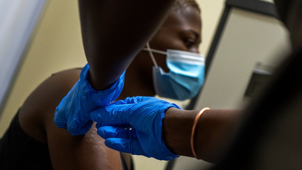 FILE - In this Nov. 30, 2020 file photo, Thabisle khlatshwayo, who received her first shot for a COVID-19 vaccine trial, receives her second AstraZeneca shot at a vaccine trial facility set at Soweto's Chris Sani Baragwanath Hospital outside Johannes