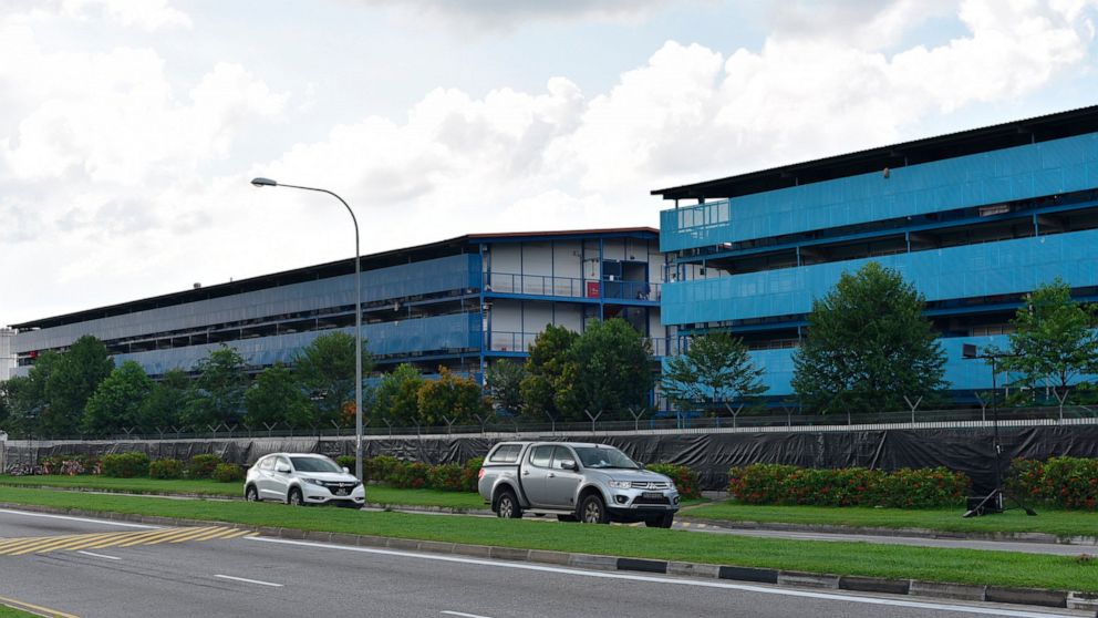 Vehicles pass the S11@Punggol foreign worker's dormitory compound, Friday, April 17, 2020 in Singapore. The city state is the latest Southeast Asian nation to surpass 5,000 COVID-19 cases, after more than 600 new cases were reported Friday. The healt