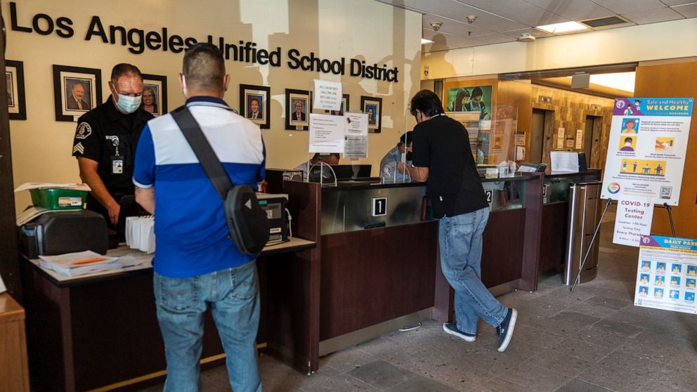 Visitors wait in line to be screened by security before being allowed to enter the Los Angeles Unified School District administrative offices in Los Angeles Thursday Sept. 9, 2021. The Los Angeles board of education is expected to vote Thursday, on w