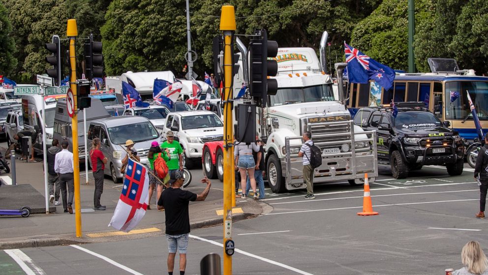 A convoy of vehicles block an intersection near New Zealand's Parliament in Wellington Tuesday, Feb. 8, 2022. Hundreds of people protesting vaccine and mask mandates drove in convoy to New Zealand's capital on Tuesday and converged outside Parliament