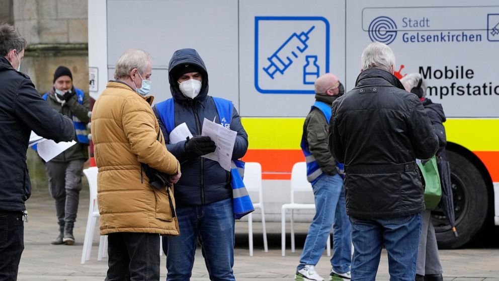 Helpers control documents at a mobile vaccination bus against the coronavirus and the COVID-19 disease in Gelsenkirchen, Germany, Monday, Nov. 29, 2021. (AP Photo/Martin Meissner)