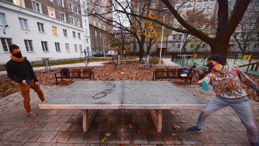Two men play table tennis in a city square in Warsaw, Poland, Saturday, Nov. 7, 2020. Due to the increase in coronavirus cases, the government introduced new restrictions in shops, schools and cultural institutions through November. (AP Photo/Czarek 